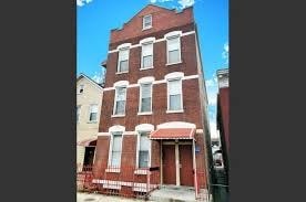 A red brick building with white trim and a red awning.