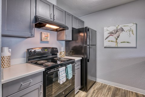 A kitchen with a stove top oven and a refrigerator.