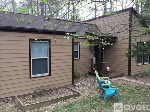A small brown house with a blue chair in front.