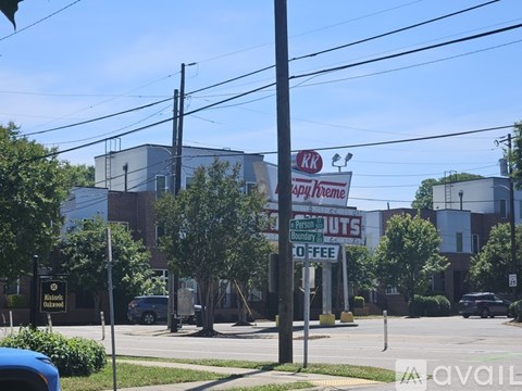 A sign for Dairy Queen is on a pole in front of a building.
