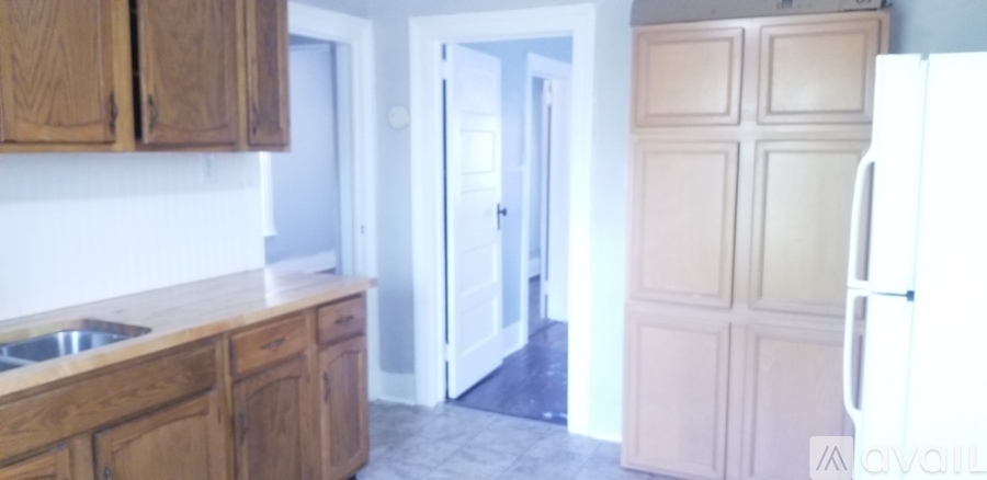 A kitchen with wooden cabinets and a white fridge.