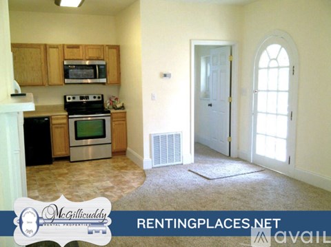 A kitchen with a microwave, oven, and stove top.