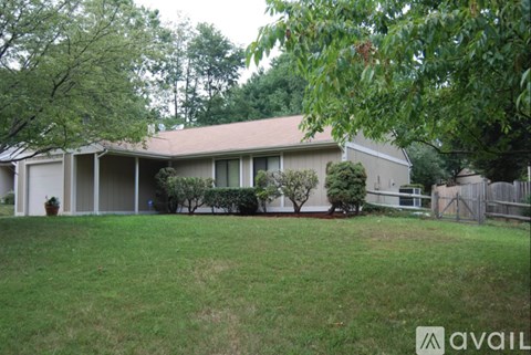 A house with a lawn and trees in front of it.