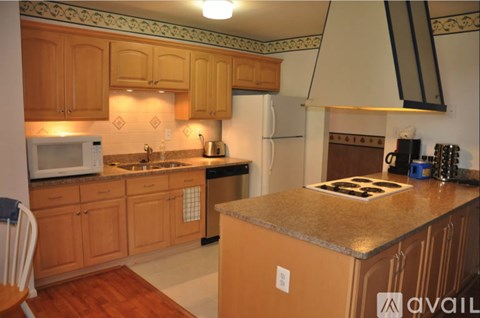 A kitchen with wooden cabinets and a white refrigerator.