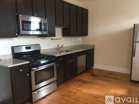 A kitchen with black cabinets and stainless steel appliances.