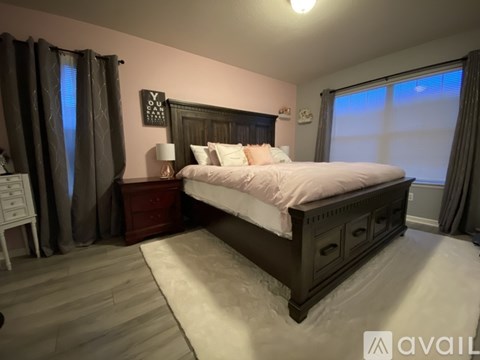 A bedroom with a large bed and a wooden headboard.