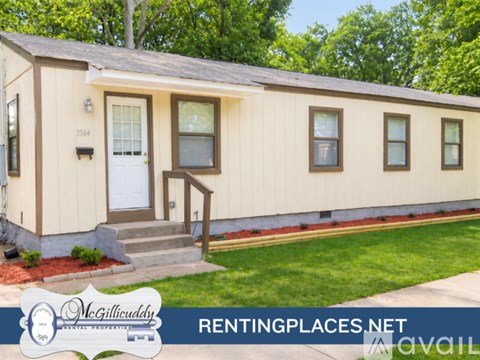A mobile home with a front porch and a front yard.