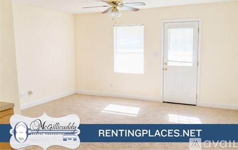 A room with a ceiling fan and a door is for rent.
