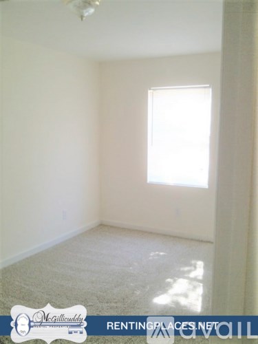 A room with a window and a carpet on the floor.