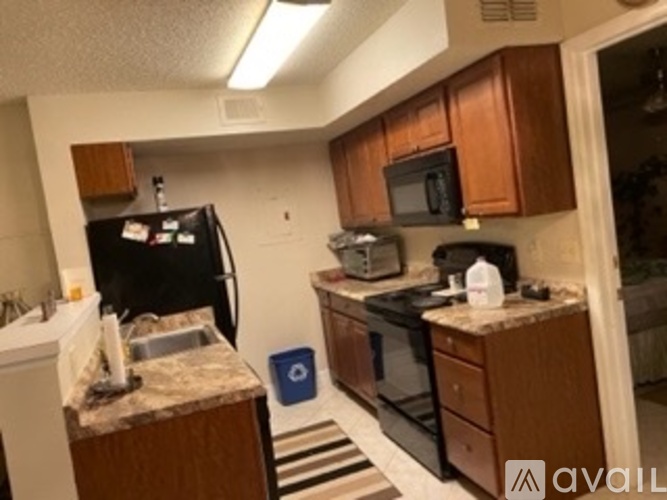 A kitchen with black appliances and wooden cabinets.