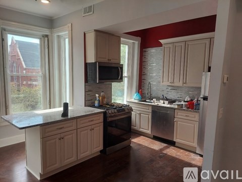 A kitchen with white cabinets and a black countertop.