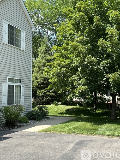 A house with a driveway and trees in the background.