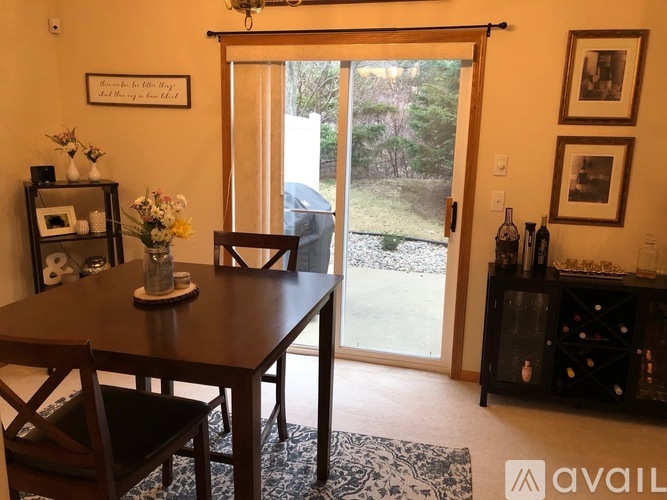 A dining room with a table and chairs and a sliding glass door.