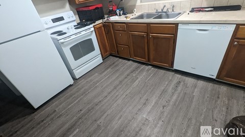 A kitchen with a white fridge, stove, and a white dishwasher.