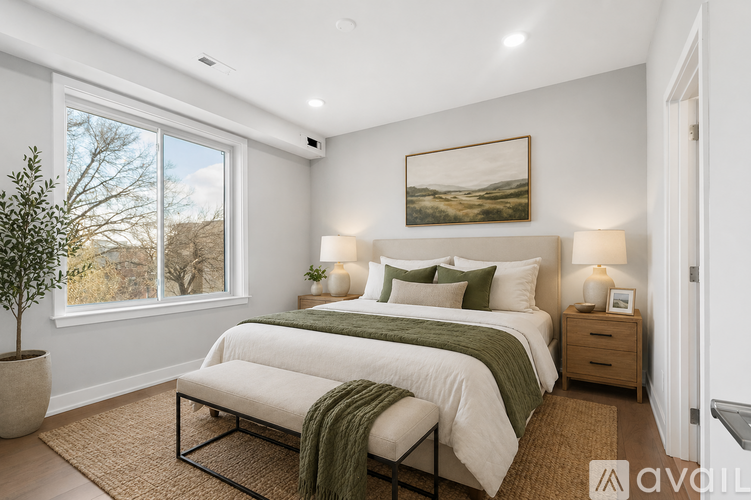 A bedroom with a large bed and a painting on the wall.
