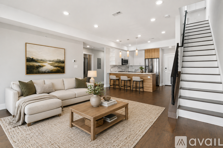 A modern living room with a staircase on the right side.