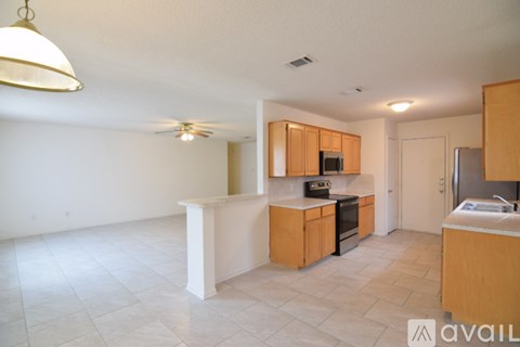 A kitchen with wooden cabinets and a fan on the ceiling.