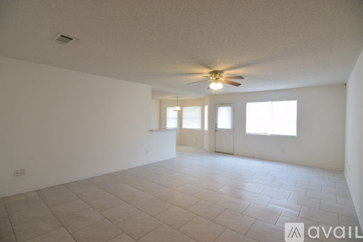 A spacious room with a ceiling fan and tiled flooring.