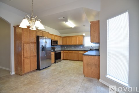 A kitchen with wooden cabinets and a refrigerator.