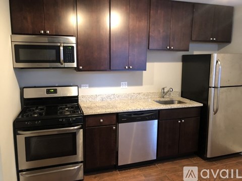 A kitchen with dark brown cabinets and stainless steel appliances.