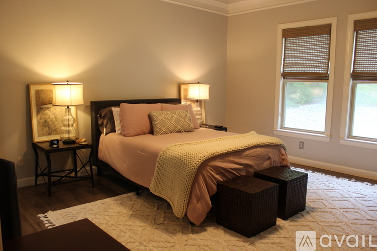 A bedroom with a large bed and two lamps on side tables.