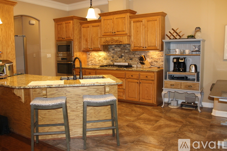 A kitchen with wooden cabinets and a marble countertop.