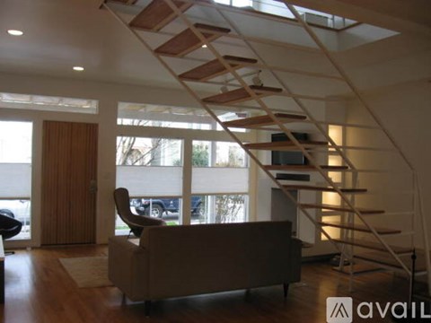 A living room with a couch and a staircase.
