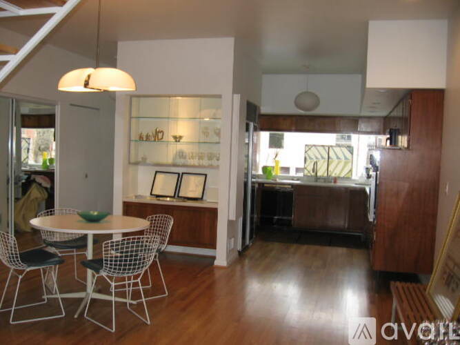 A modern dining room with a glass display cabinet and a round table with four chairs.