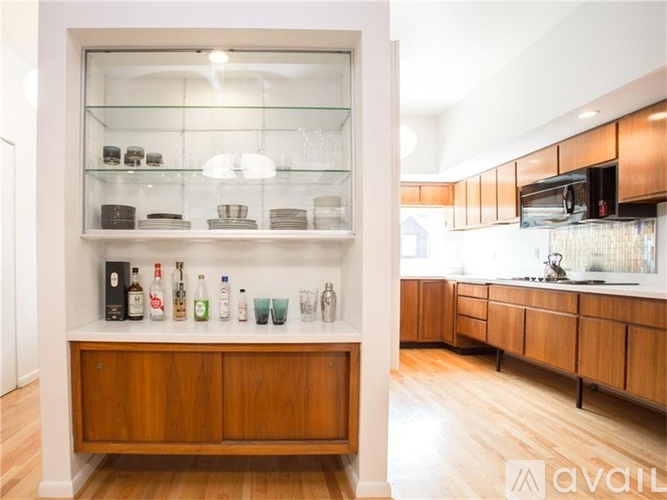 A modern kitchen with a wooden cabinet and a glass display case.