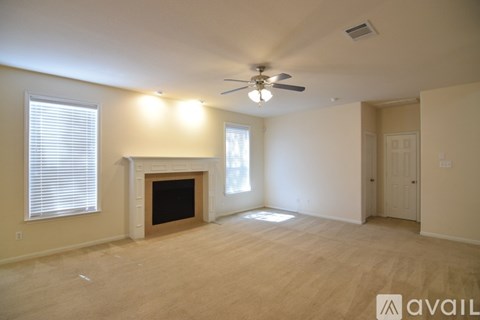 A living room with a fireplace and a ceiling fan.