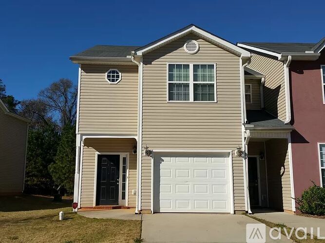 A two-story house with a garage door and a small window above it.