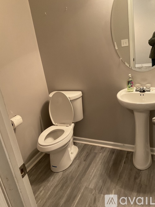 A white toilet and sink in a bathroom.