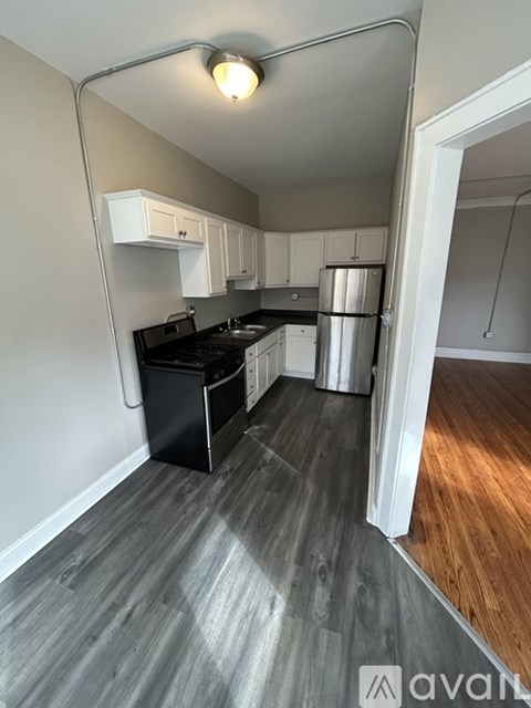 A kitchen with a black fridge and stove top.