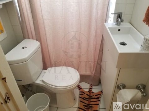A bathroom with a toilet, sink, and shower curtain.