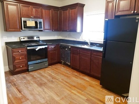 A kitchen with wooden cabinets and black appliances.