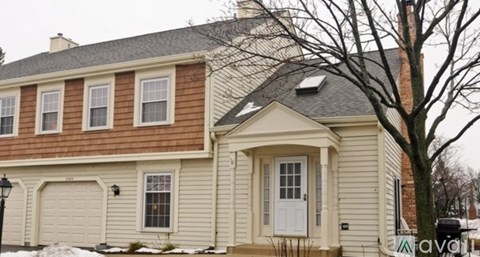 A two-story house with a white door and windows.