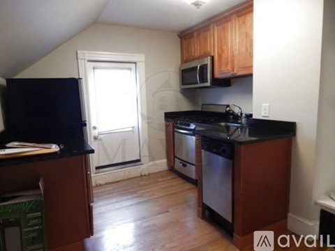 A kitchen with wooden cabinets and a black countertop.