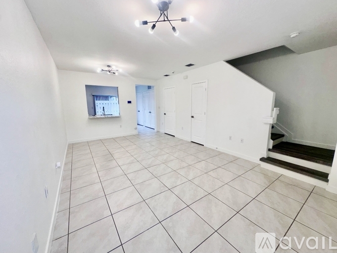 A spacious room with white cabinets and a tiled floor.