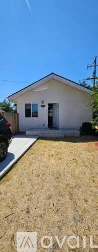 A small white house with a black door and windows.