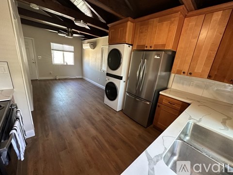 A kitchen with wooden cabinets and a stainless steel refrigerator.