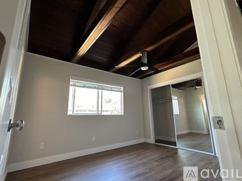 A room with wooden ceiling and a sliding glass door.