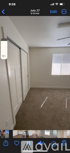 A room with white walls and a brown carpet is shown.