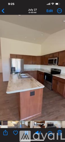 A kitchen with wooden cabinets and a marble countertop.