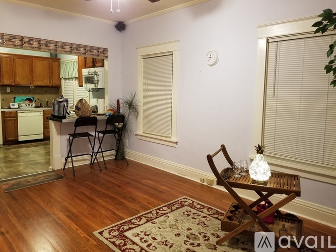 A living room with a wooden floor and a rug.