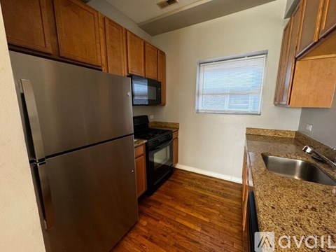 A kitchen with a stainless steel refrigerator, microwave, oven, and sink.
