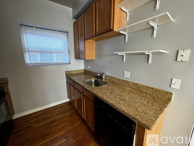 A kitchen with wooden cabinets and a granite countertop.