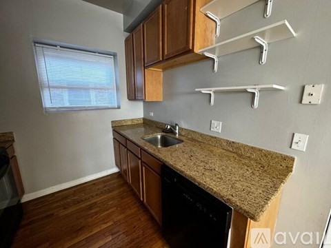 A kitchen with wooden cabinets and a granite countertop.