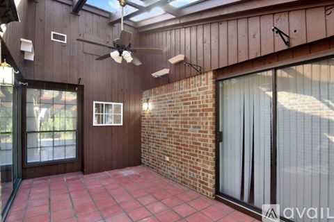 A wooden deck overlooks a garden with a variety of trees.