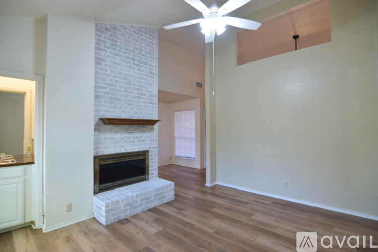 A living room with a fireplace and a fan.