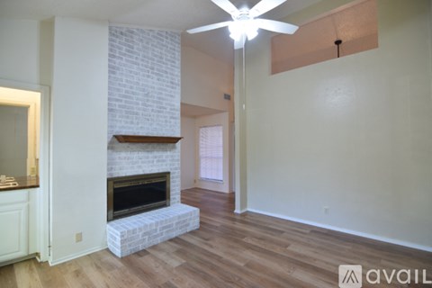 A living room with a fireplace and a fan.